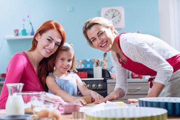 A family of three girls making pastry in a full color kitchen