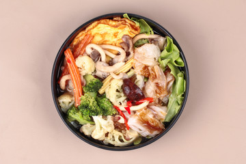 Fried big noodle  with omelet topped mixed vegetable in soup.