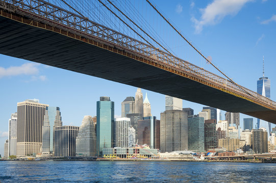 Bright scenic view of the Brooklyn Bridge with the Lower Manhattan skyline from the East River