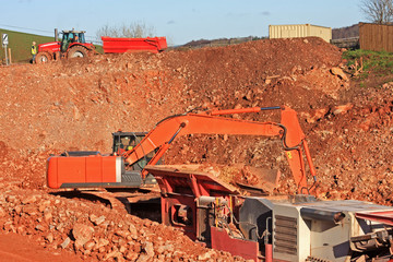 Digger loading a stone crusher