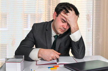Depressed businessman with headache in the office