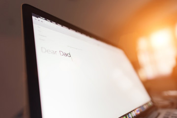 laptop with text an email to Dad in bedroom with dim light, Concept : father day, homesick.