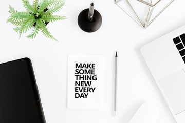 flat lay with Make something new everyday motivational quote on modern workplace with wireless devices