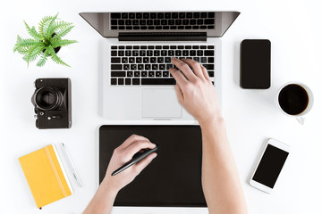 top view of hands using graphic tablet and laptop at modern workplace