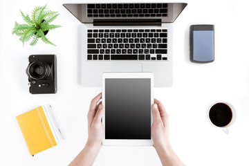 top view of hands holding digital tablet at modern workplace