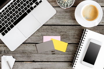 top view of wireless digital devices, coffee cup and blank cards on workplace