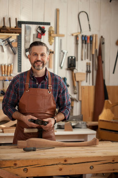 Happy Carpenter/Middle ages handsome carpenter finished creating cabriolet legs and smiles to the camera