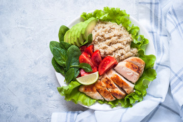 Fresh salad from quinoa, chicken breast, spinach, lettuce and tomato