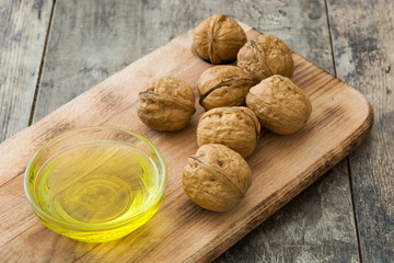 Walnuts oil on wooden background
