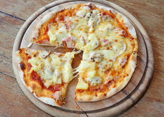 Delicious homemade pizza served on wood tray against wooden table