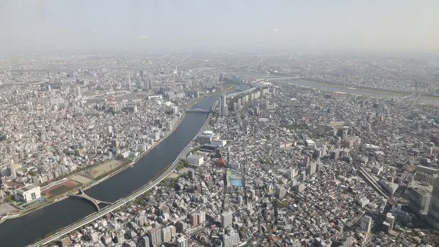 Aerial view time lapse of Tokyo city skyline, Sumida River Bridges and Asakusa area from Tokyo Skytree observatory. Daytime, Japan.