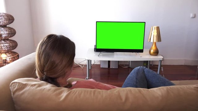 Girl Watching Television Resting On Couch. Girl watching green screen television lying down on the couch