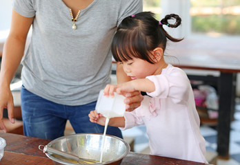 Mother and Little girl making Homemade pancake.