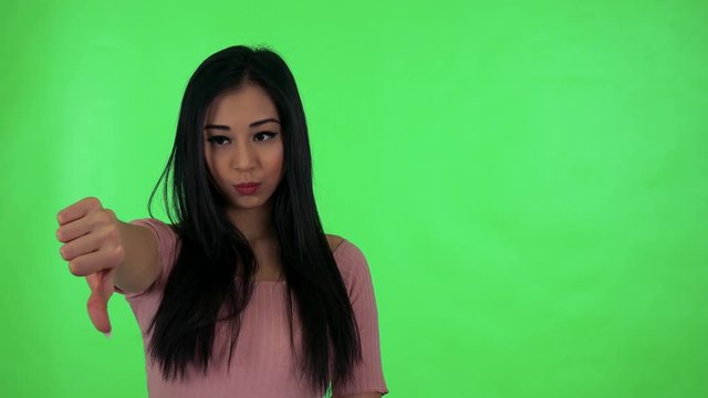 young attractive asian woman disagrees - green screen studio