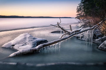 Obraz premium Scenic landscape with icicles and lake at the winter evening