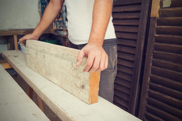 Carpenter holding a raw board / wood prepared for fine works.