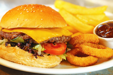 Burger, french fries and onion rings with barbeque sauce