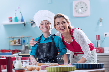 Mom preparing pastry with her son in their colorful kitchen