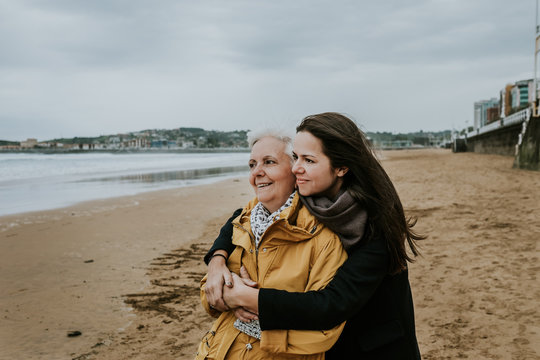 Beautiful images of a mother and daughter on the beach in Autumn. Lifestyle portraits.