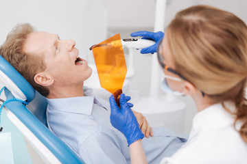 Focused smart man undergoing dental manipulation