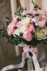Beautiful wedding bouquet with roses and peonies closeup