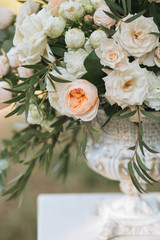 Bouquets of white roses, peonies and eucalyptus in vases