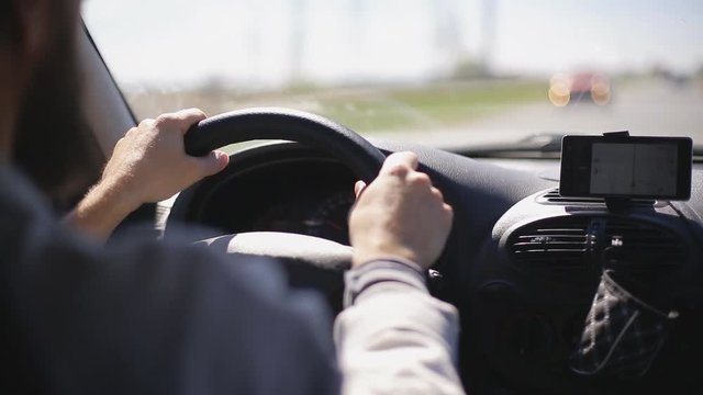 Man rides a car with a navigator on a smartphone