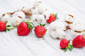 Natural still life with ripe strawberries and cotton flowers