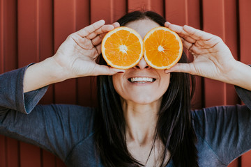 .Funny portraits of a pretty girl with two fresh oranges in her eyes with different expressions. Lifestyle portrait