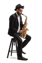 Jazz musician playing saxophone and sitting on chair