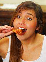 Close up of a beauty woman in a restaurant eating a delicious chicken wings