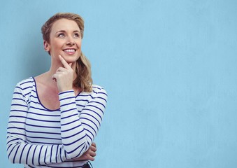 Obraz premium woman with hand on chin looking away over blue background