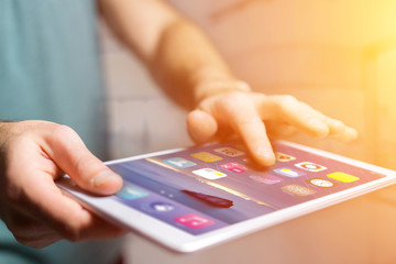 Hand holding black tablet with operating system screen
