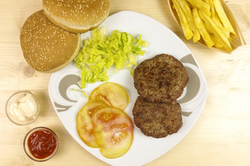 Hamburgers in a plate on wooden background - top view
