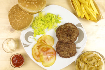 Hamburgers in a plate on wooden background - top view