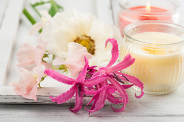 Flowers and candles on old wooden background