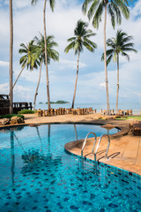 Swimming pool of luxury hotel and  tropical palm trees