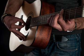 Fototapeta na wymiar Playing guitar. Acoustic guitar in the hands of the guitarist. Horizontal frame