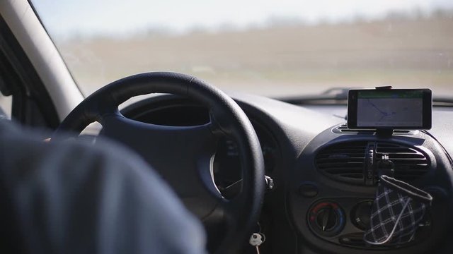 Man rides a car with a navigator on a smartphone