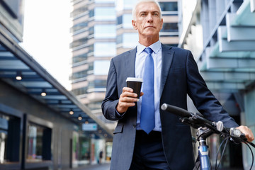 Successful businessman riding bicycle