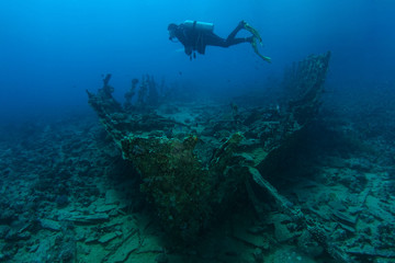 Fototapeta na wymiar Scuba diver swim over very old ship wreck