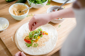 Wrap with zucchini, arugula, paprika, hummus and parmesan cheese