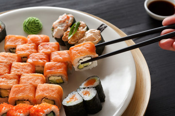 Eating sushi and rolls in japanese restaurant