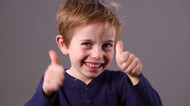 cheerful young preschool red hair child showing his satisfaction 