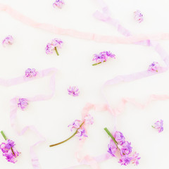 Pattern made of pink petals and shabby tapes on white background. Flat lay, top view.