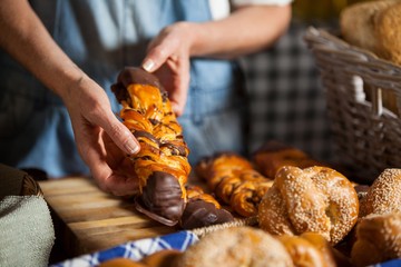 Mid-section of female staff arranging sweet foods