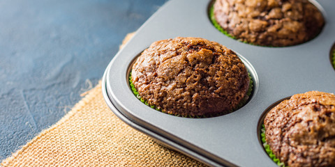 Banana chocolate muffins with caramel sugar topping on dark background