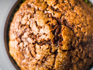 Banana chocolate muffins with caramel sugar topping on dark background