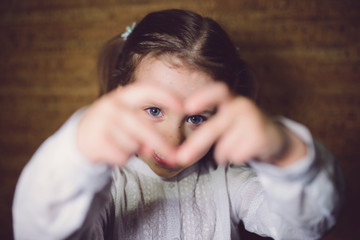 Girl Looking through Fingers