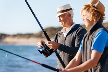 Senior man fishing with his grandson